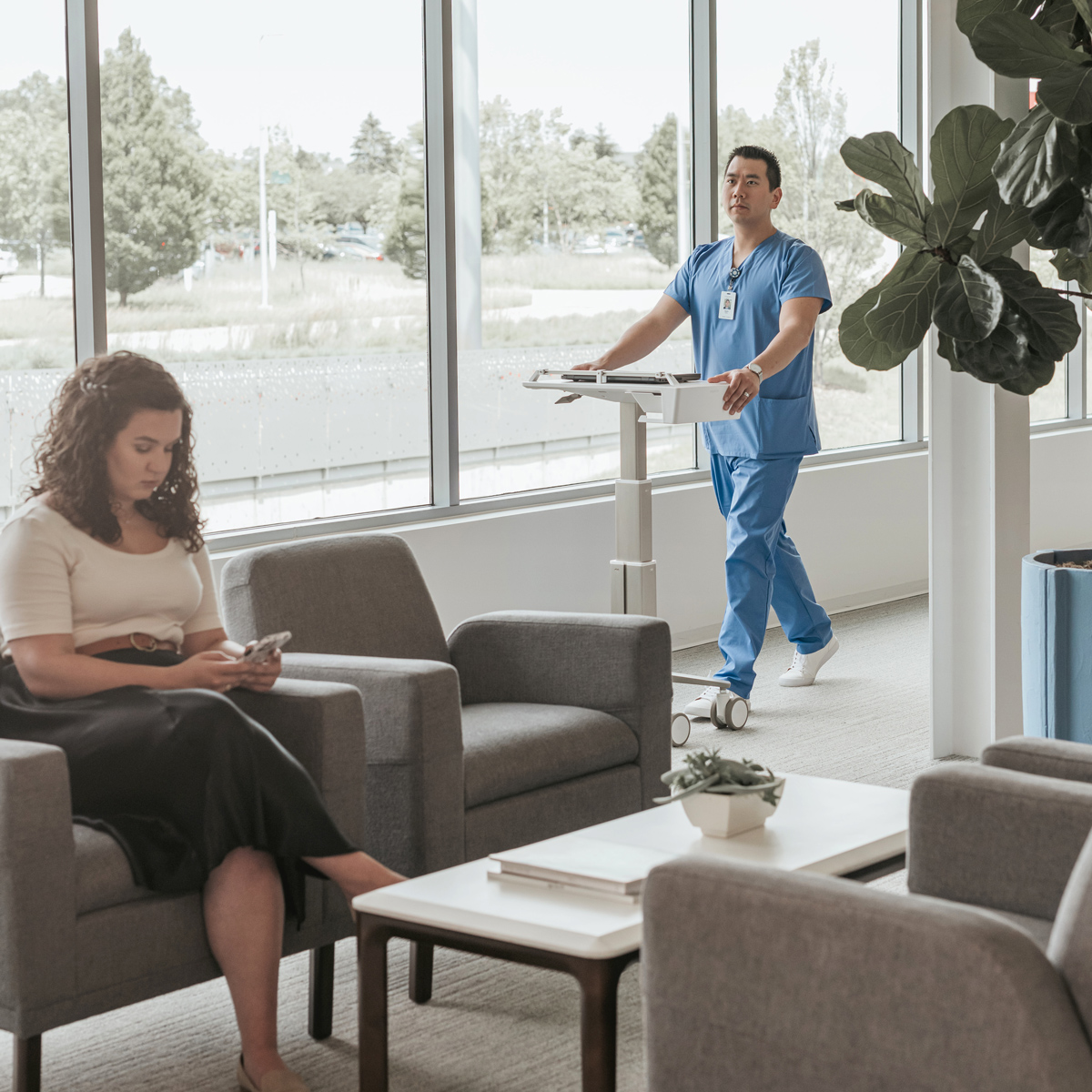 hospital Nurse walking through a hallway into a seating area