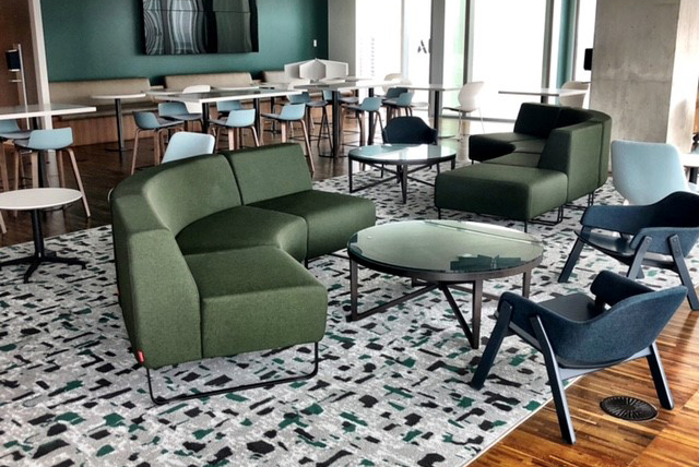 accor-image-2 Two couches and two arm chairs surrounding small tables with long tables in the background