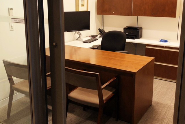 accor-image-3 Small office area with a desk and an office chair facing two wooden arm chairs