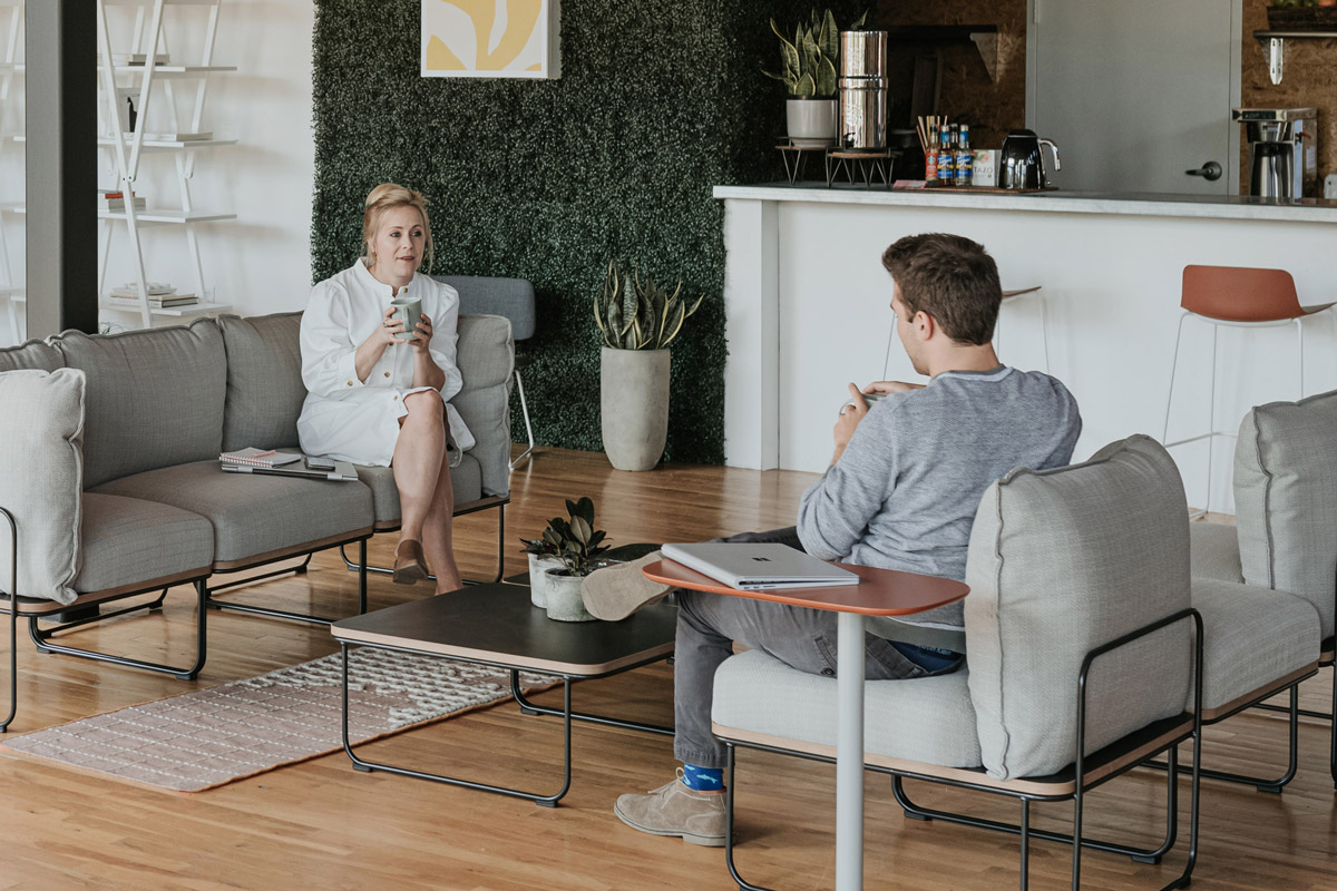 Man and woman sitting on opposite couches and talking