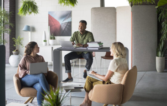 Community Space featuring Poppy Lounge, and BuzziScreen Mix people chatting at the office